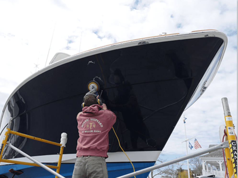 A man is working on the side of a boat.